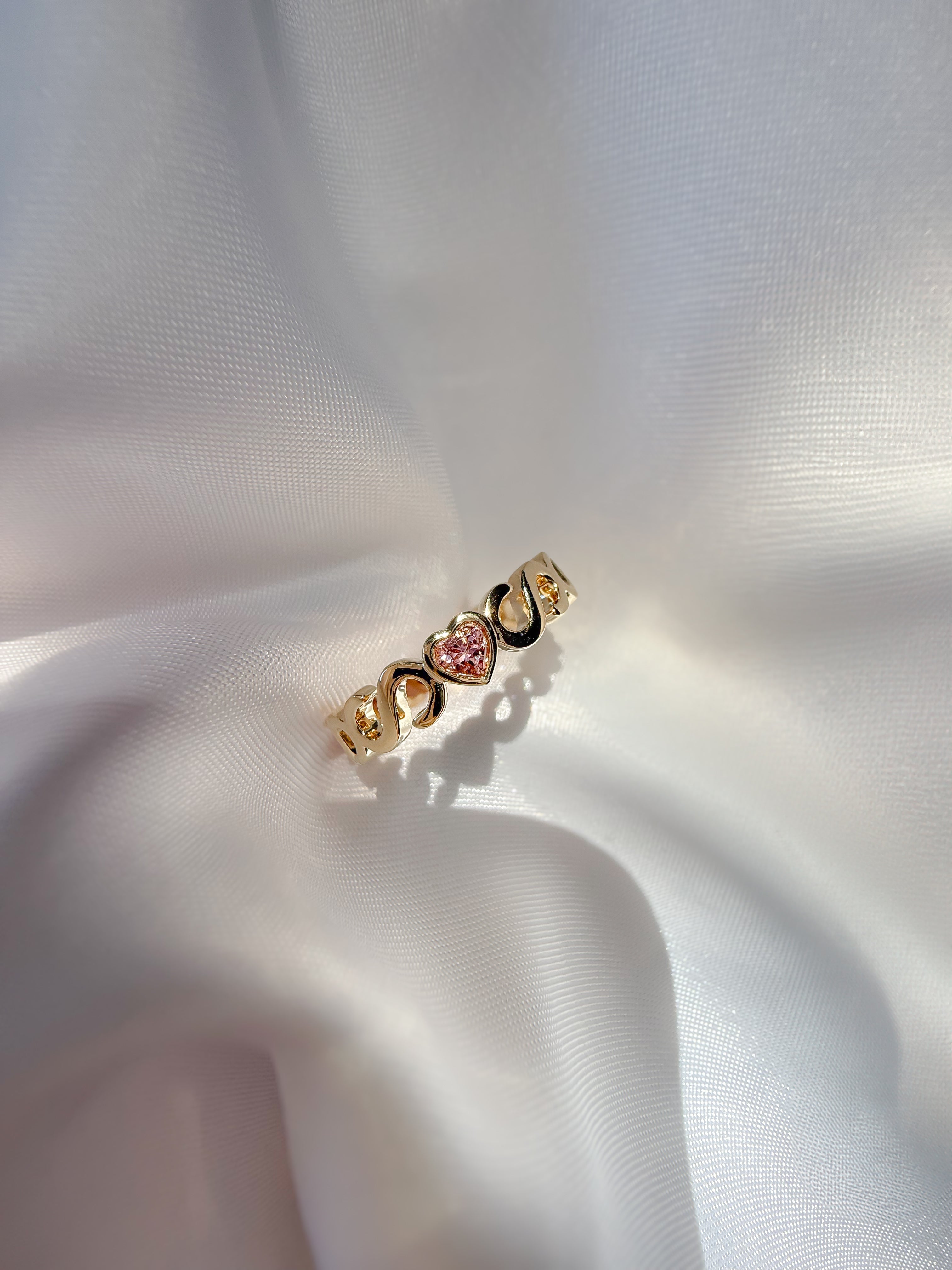 Casoni Connected Hearts Ring in yellow gold with interlocking C design and pink heart tourmaline