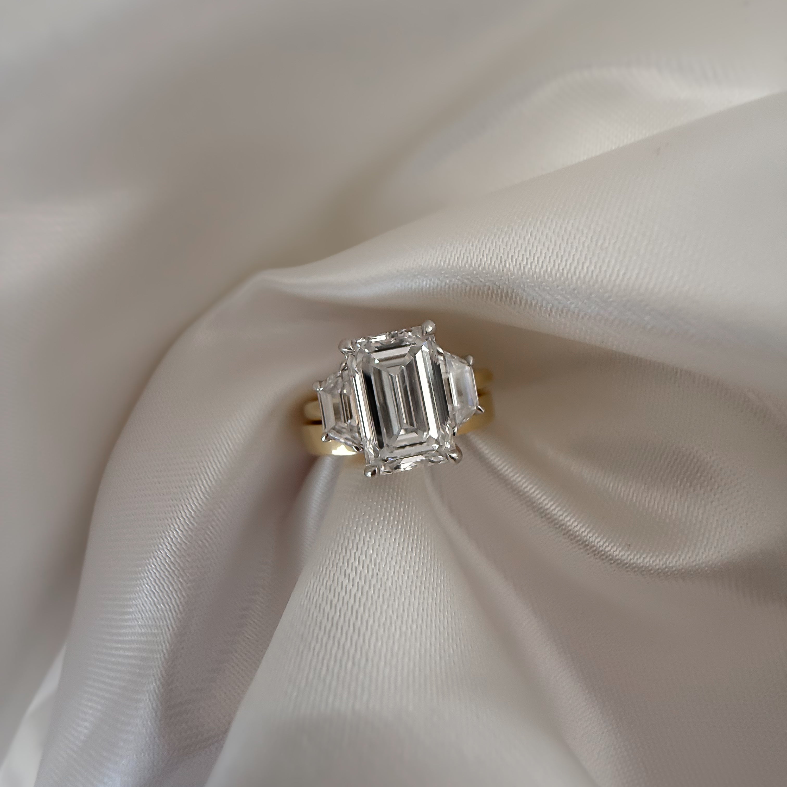 18ct Yellow Gold trilogy Ring featuring Emerald Cut Diamond and two side stones 