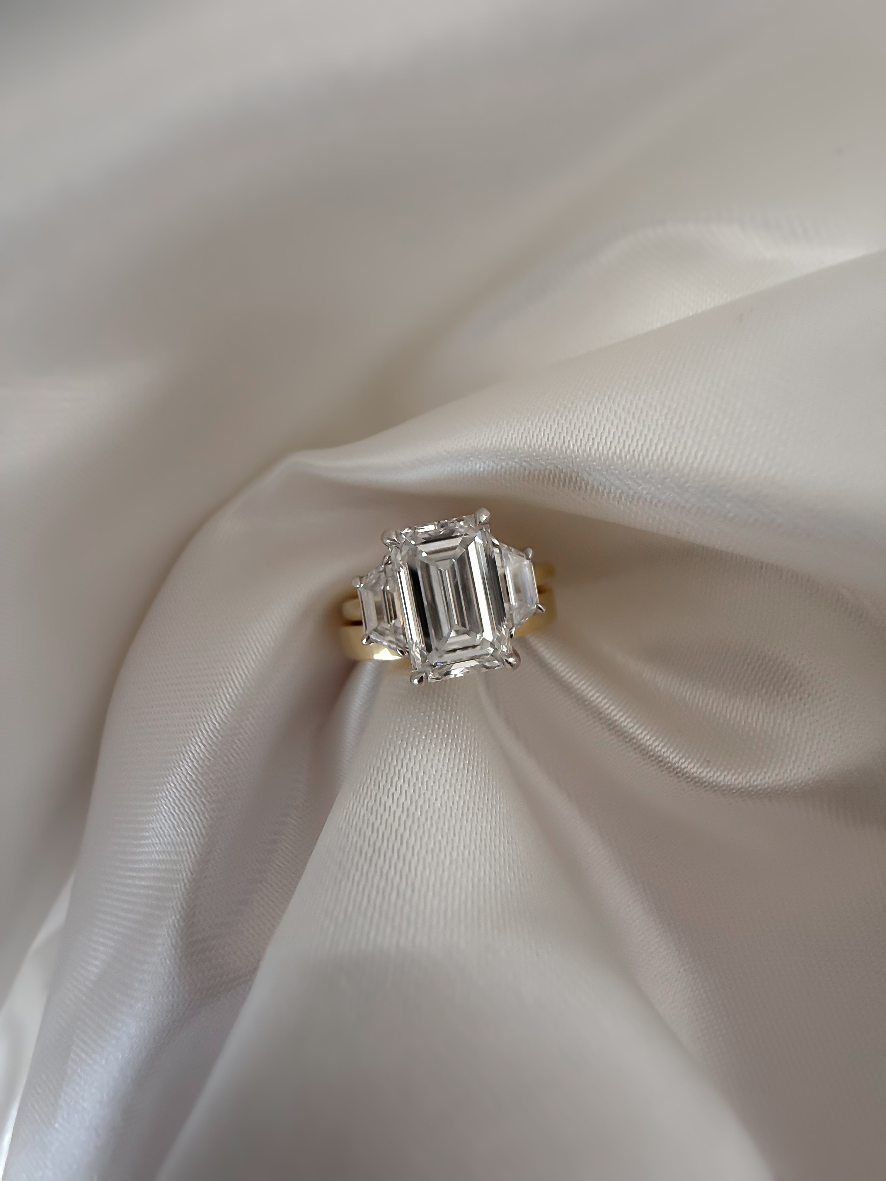 18ct Yellow Gold trilogy Ring featuring Emerald Cut Diamond and two side stones 