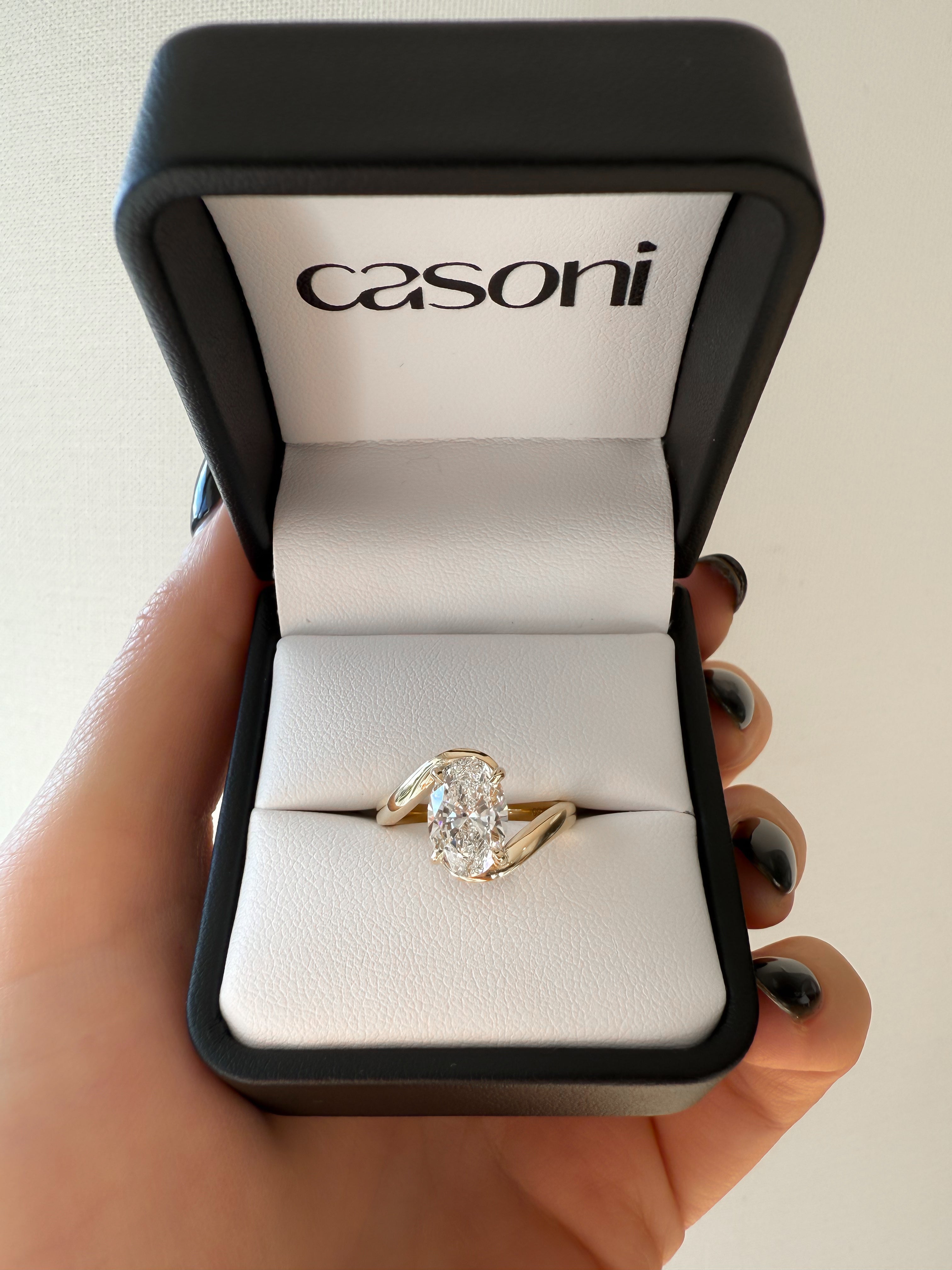 18ct Yellow Gold ring in a Casoni box held by a hand