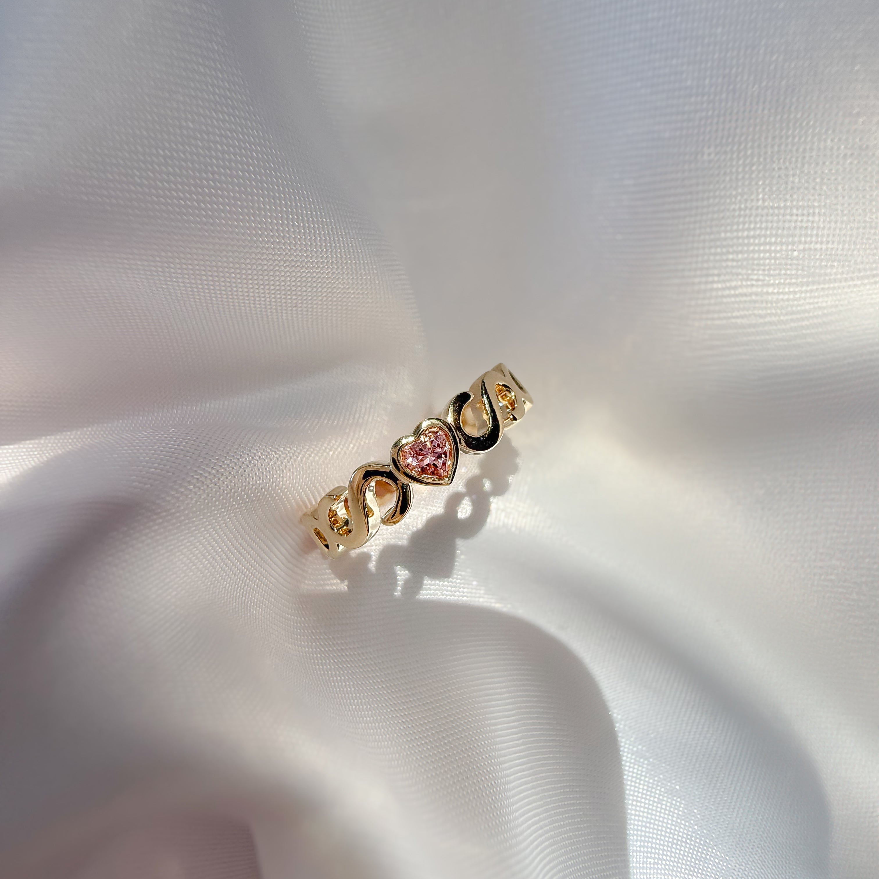Casoni Connected Hearts Ring in yellow gold with interlocking C design and pink heart tourmaline 